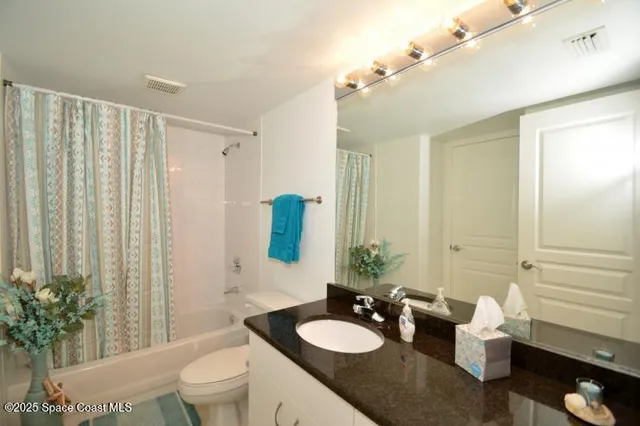 a bathroom with a sink vanity granite and toilet