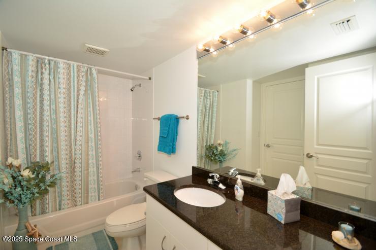 8700 Ridgewood Avenue, Unit B310 Cape Canaveral, FL 32920 - Photo 21 of 23 a bathroom with a sink vanity granite and toilet