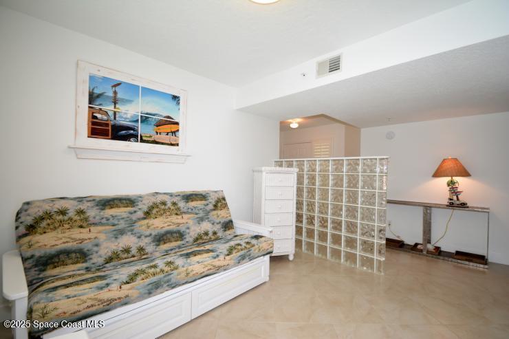 8700 Ridgewood Avenue, Unit B310 Cape Canaveral, FL 32920 - Photo 3 of 23 a bedroom with a bed and a cabinets