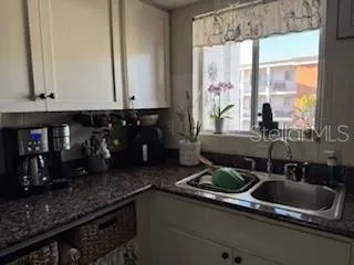 a kitchen with sink a window and cabinets