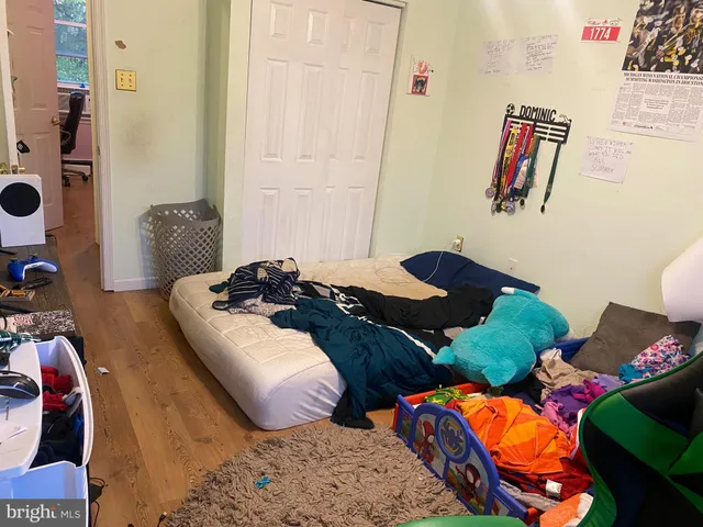 a bedroom with two bed and a painting on the wall