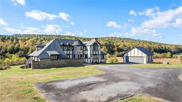 a view of house with a big yard and large trees