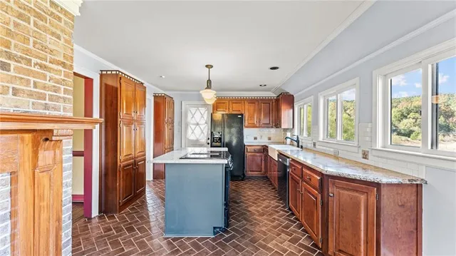 a kitchen with stainless steel appliances granite countertop a refrigerator a sink dishwasher a stove and a dining table with wooden floor