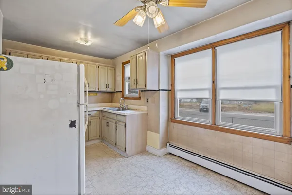 a kitchen with window cabinets and refrigerator
