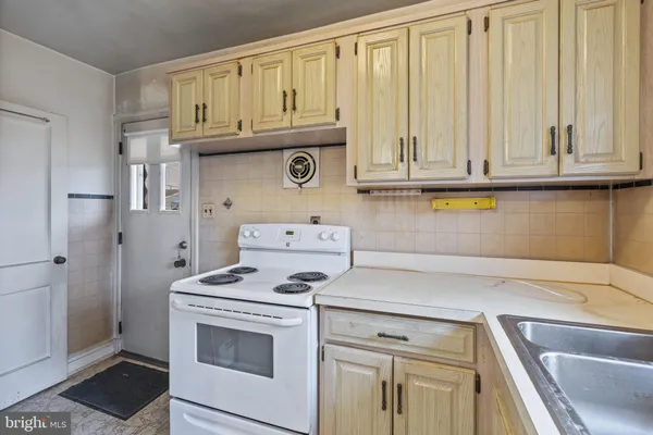 a kitchen with granite countertop white cabinets and a stove with a wooden floors