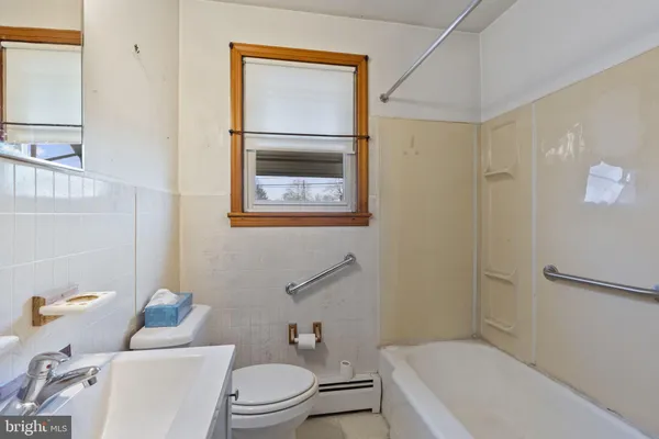 a white toilet sitting next to a bathroom sink and tub