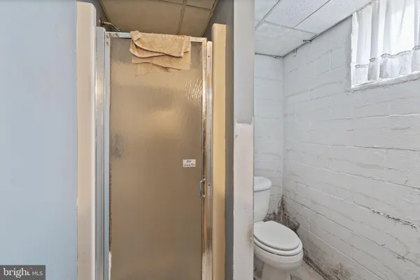 a bathroom with a granite countertop toilet and a shower