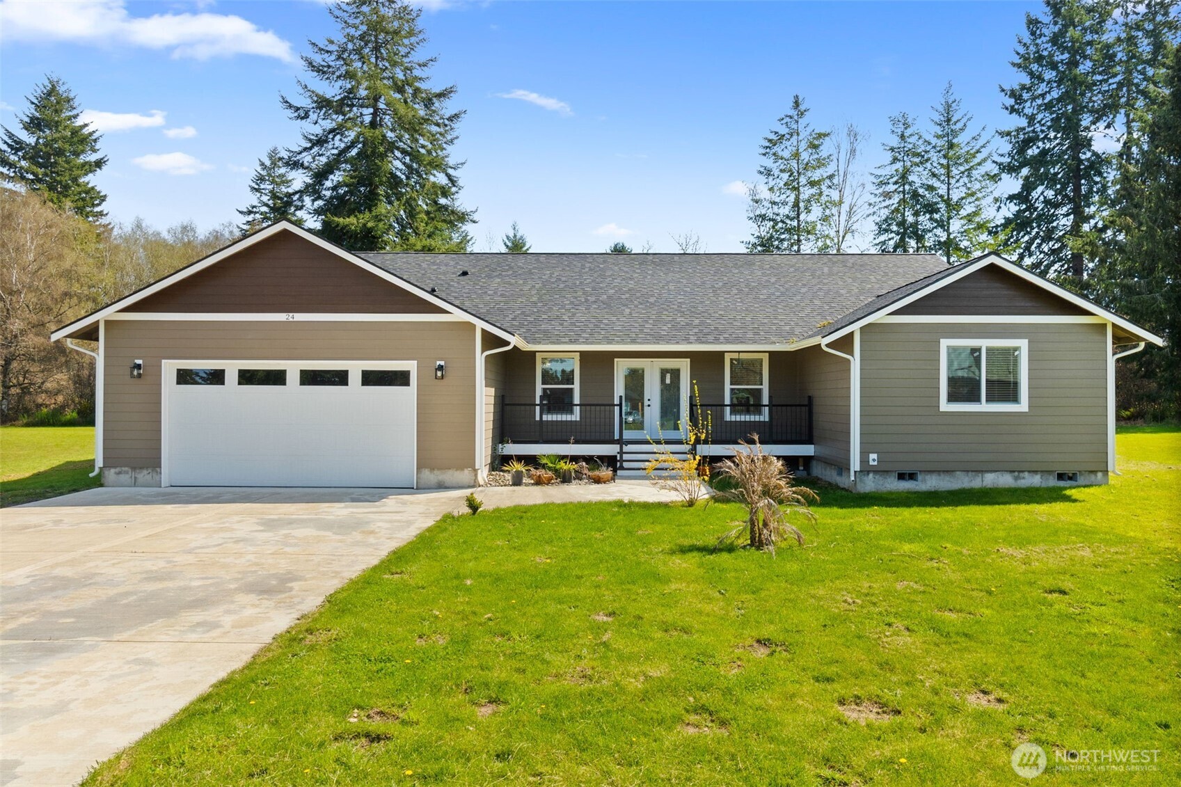 24 Hurd Road Elma, WA 98541 - Photo 1 of 26 a front view of a house with a garden and trees