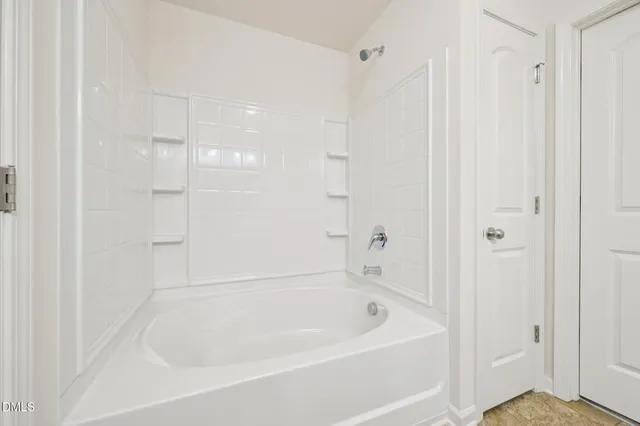 a white bath tub sitting next to a shower