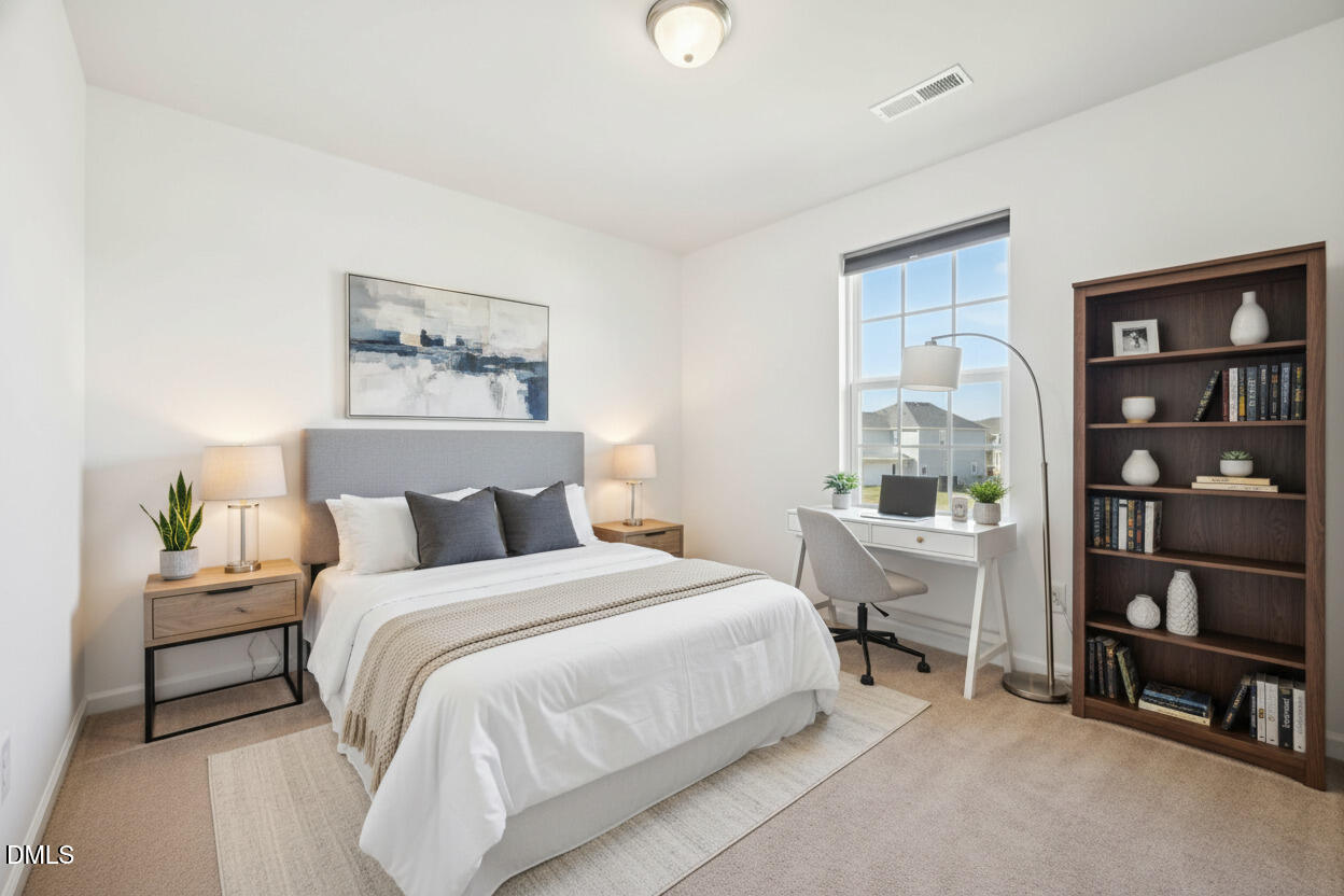 2020 Creek Road Nashville, NC 27856 - Photo 19 of 26 a bedroom with a bed a table and a bookshelf