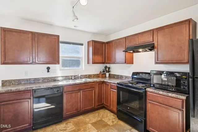 a kitchen with a sink stove top oven and cabinets