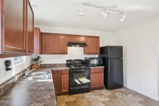 a kitchen with stainless steel appliances granite countertop a stove a refrigerator and a sink