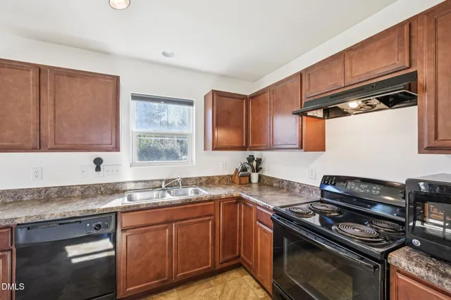 a kitchen with granite countertop a sink stove and cabinets