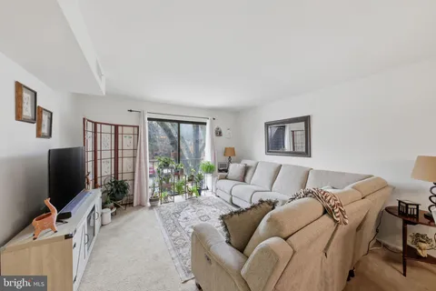 a living room with furniture a flat screen tv and a large window