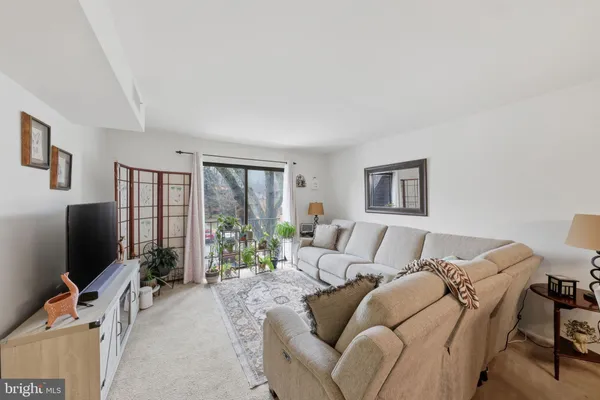 a living room with furniture a flat screen tv and a large window