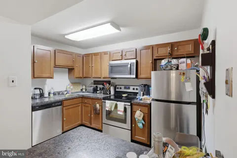a kitchen with stainless steel appliances granite countertop a refrigerator sink and microwave