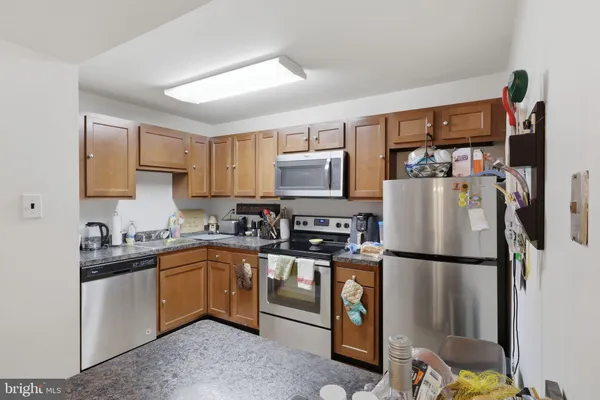 a kitchen with stainless steel appliances granite countertop a refrigerator sink and microwave
