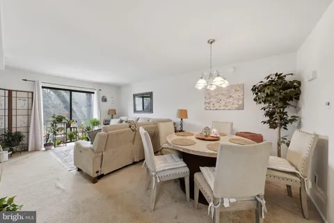 a dining room with furniture a chandelier and window