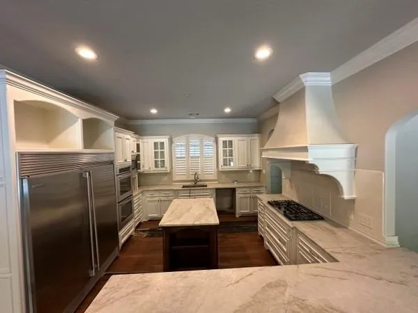 a kitchen with refrigerator and white cabinets
