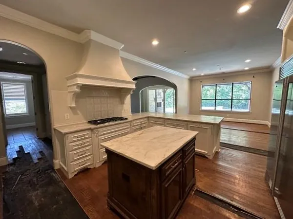 a kitchen that has a sink a stove and a wooden floor
