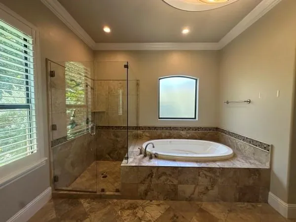 a bathroom with a granite countertop sink a mirror and a bathtub