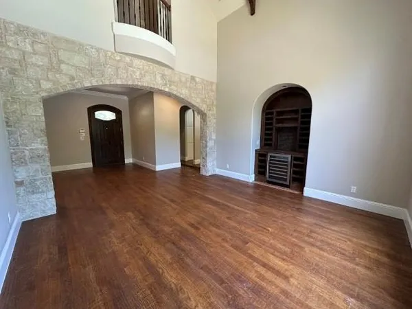 an empty room with wooden floor and mirror