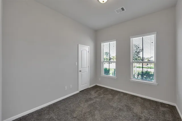 a view of an empty room with a chandelier fan