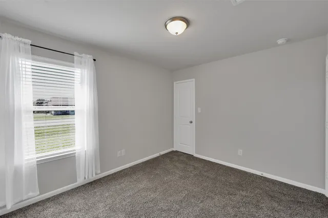 a view of a hallway with wooden floor and a cabinet