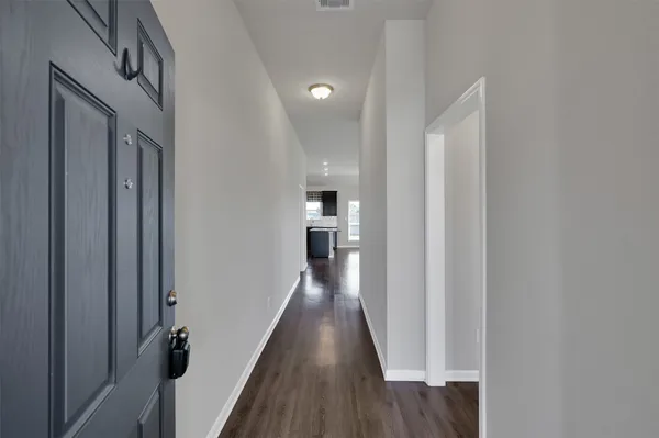 a view of a hallway with wooden floor and staircase