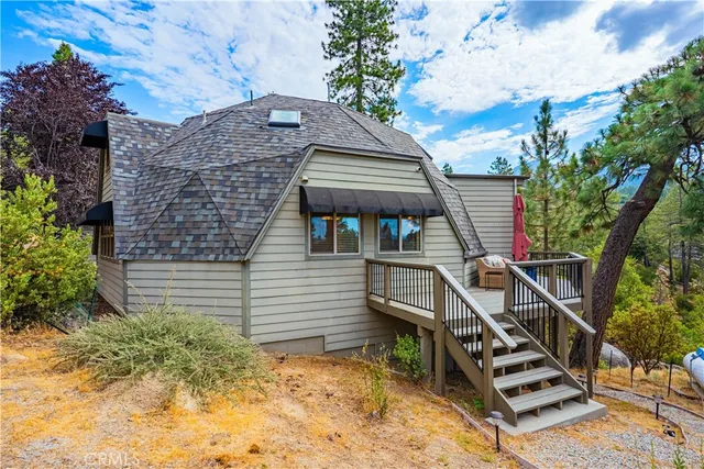 a kitchen with stainless steel appliances granite countertop a refrigerator a sink dishwasher a stove and a dining table with wooden floor