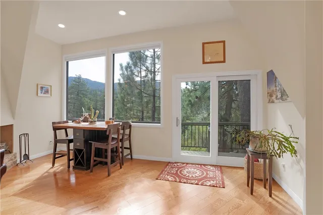 a kitchen with stainless steel appliances granite countertop a stove top oven a sink dishwasher and a dining table with wooden floor