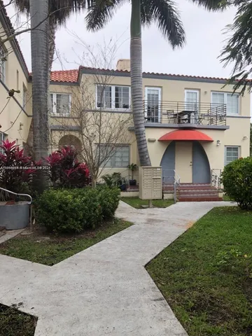 a front view of a house with a garden and plants