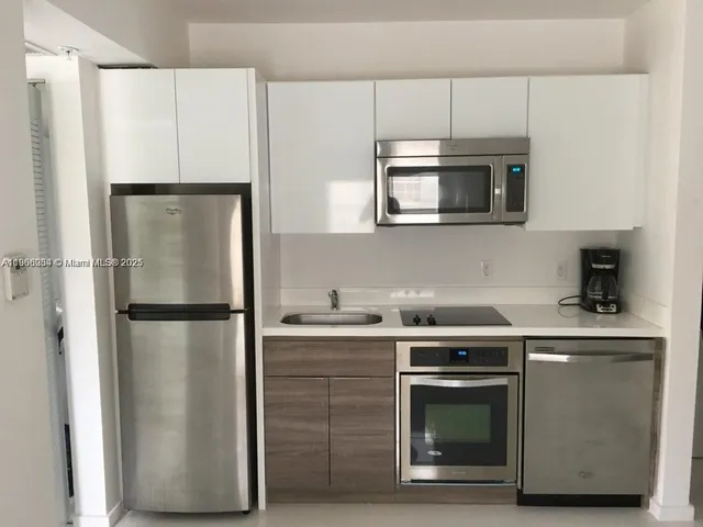 a kitchen with stainless steel appliances a refrigerator sink and microwave