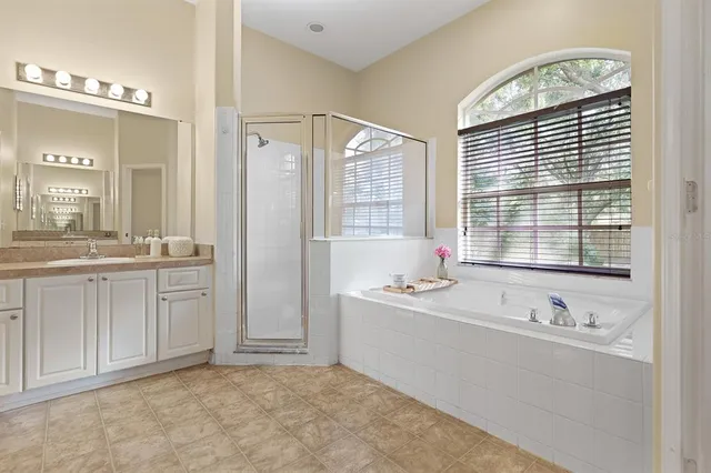 a spacious bathroom with double vanity a mirror a bathtub and a shower