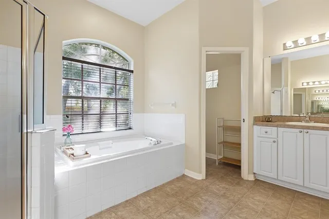 a bathroom with a tub sink and mirror