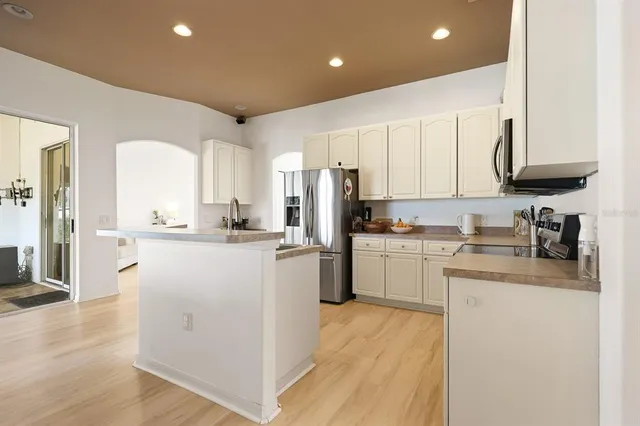 a kitchen with a refrigerator a sink and cabinets