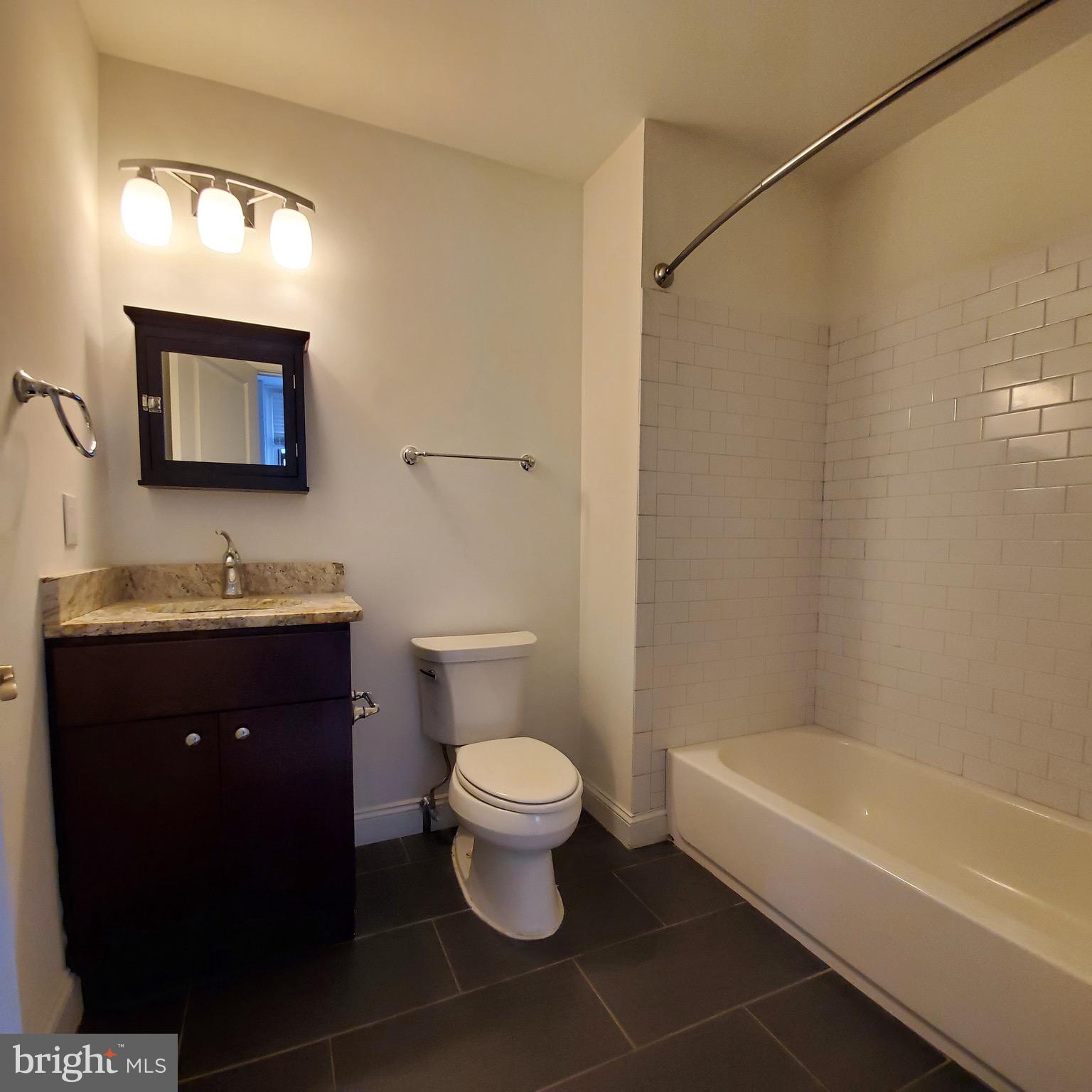 421-429 Monroe Street, Unit 102 Philadelphia, PA 19147 - Photo 6 of 10 a bathroom with a toilet a sink and bathtub