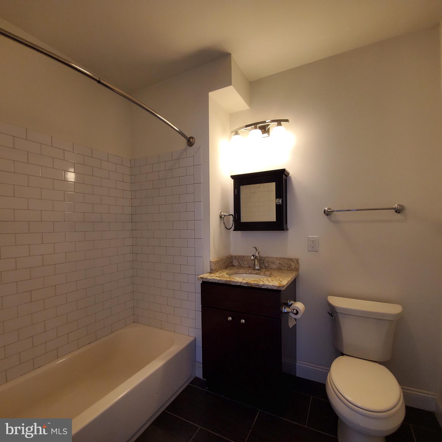 421-429 Monroe Street, Unit 102 Philadelphia, PA 19147 - Photo 7 of 10 a bathroom with a toilet a sink and bathtub