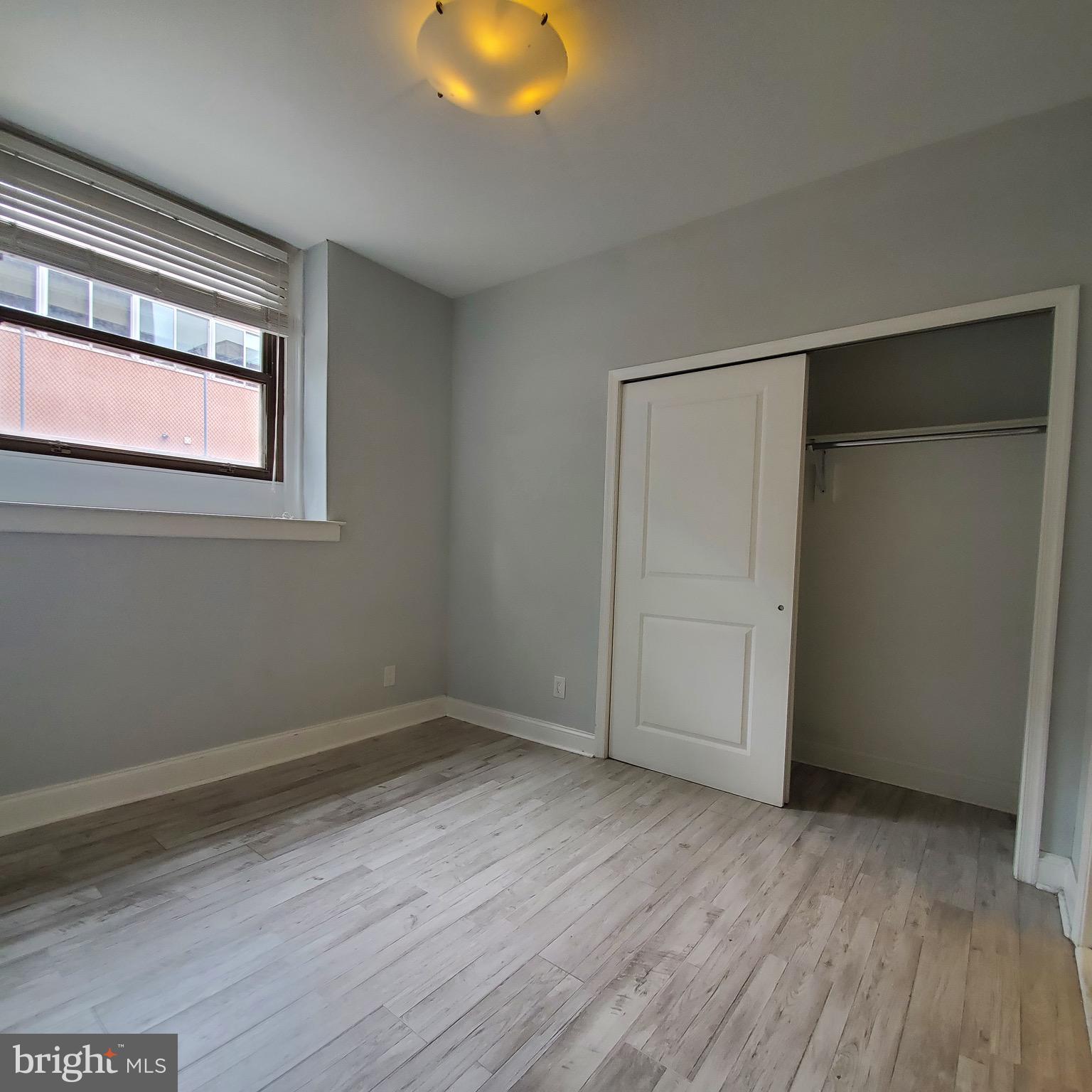 421-429 Monroe Street, Unit 102 Philadelphia, PA 19147 - Photo 10 of 10 an empty room with wooden floor and windows