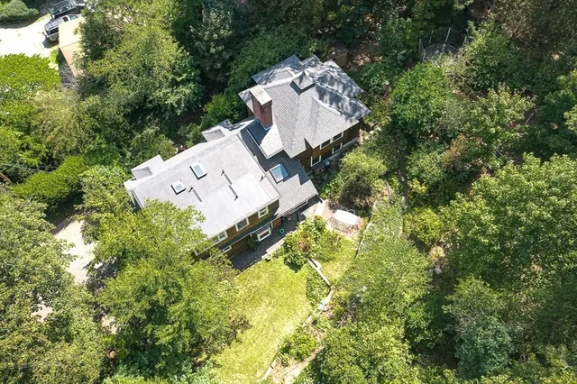 an aerial view of a house with swimming pool and garden space