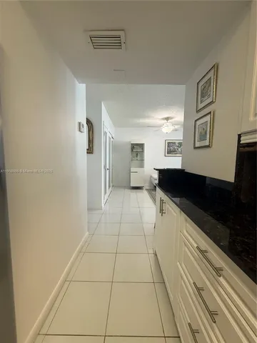 a large white kitchen with a sink and cabinets