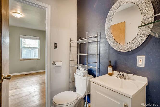 3880 Quay Street Wheat Ridge, CO 80033 - Photo 8 of 32 a bathroom with a sink a mirror and a toilet