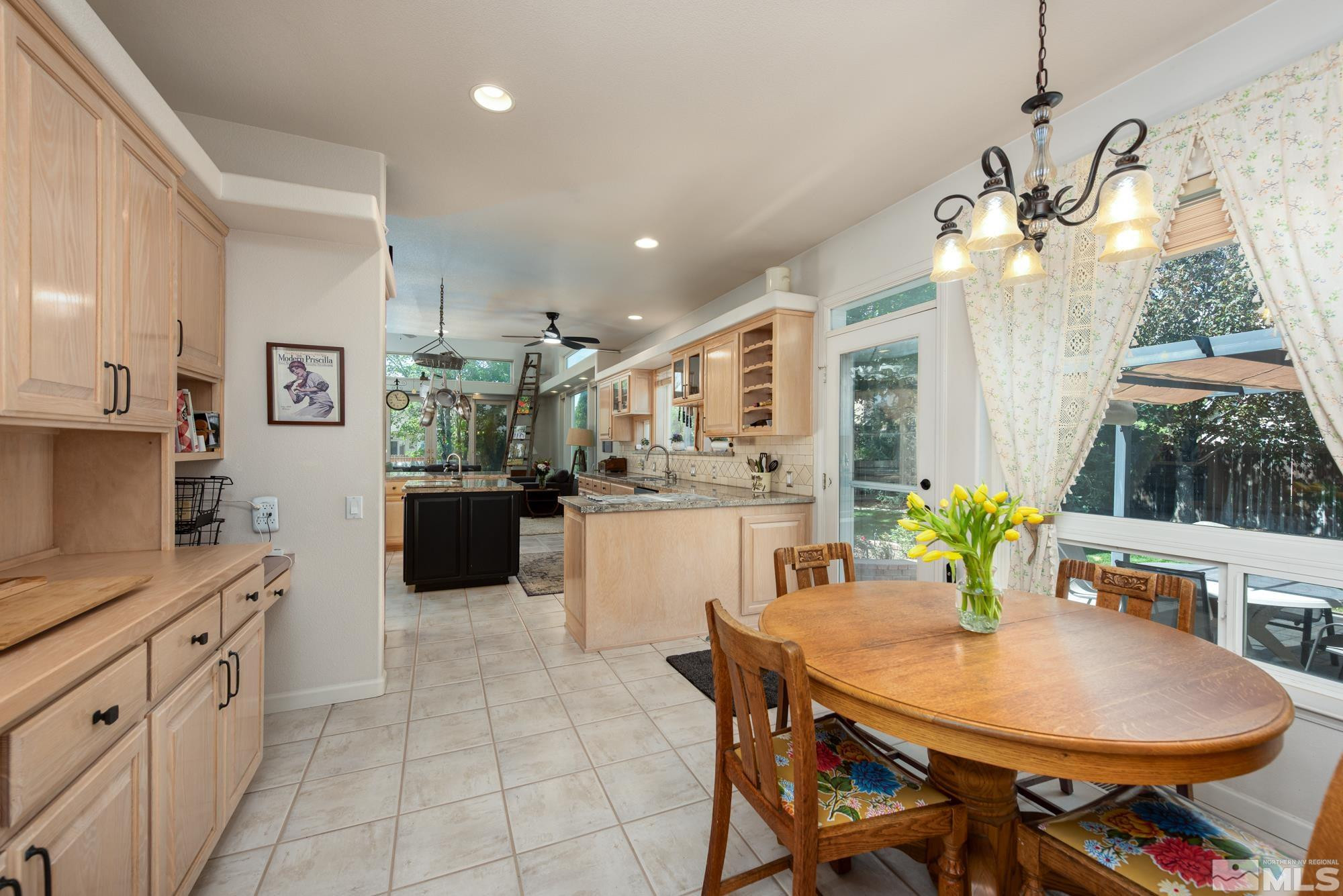 971 Fieldgate Way Gardnerville, NV 89460 - Photo 14 of 57 a kitchen with stainless steel appliances kitchen island granite countertop a table chairs and white cabinets