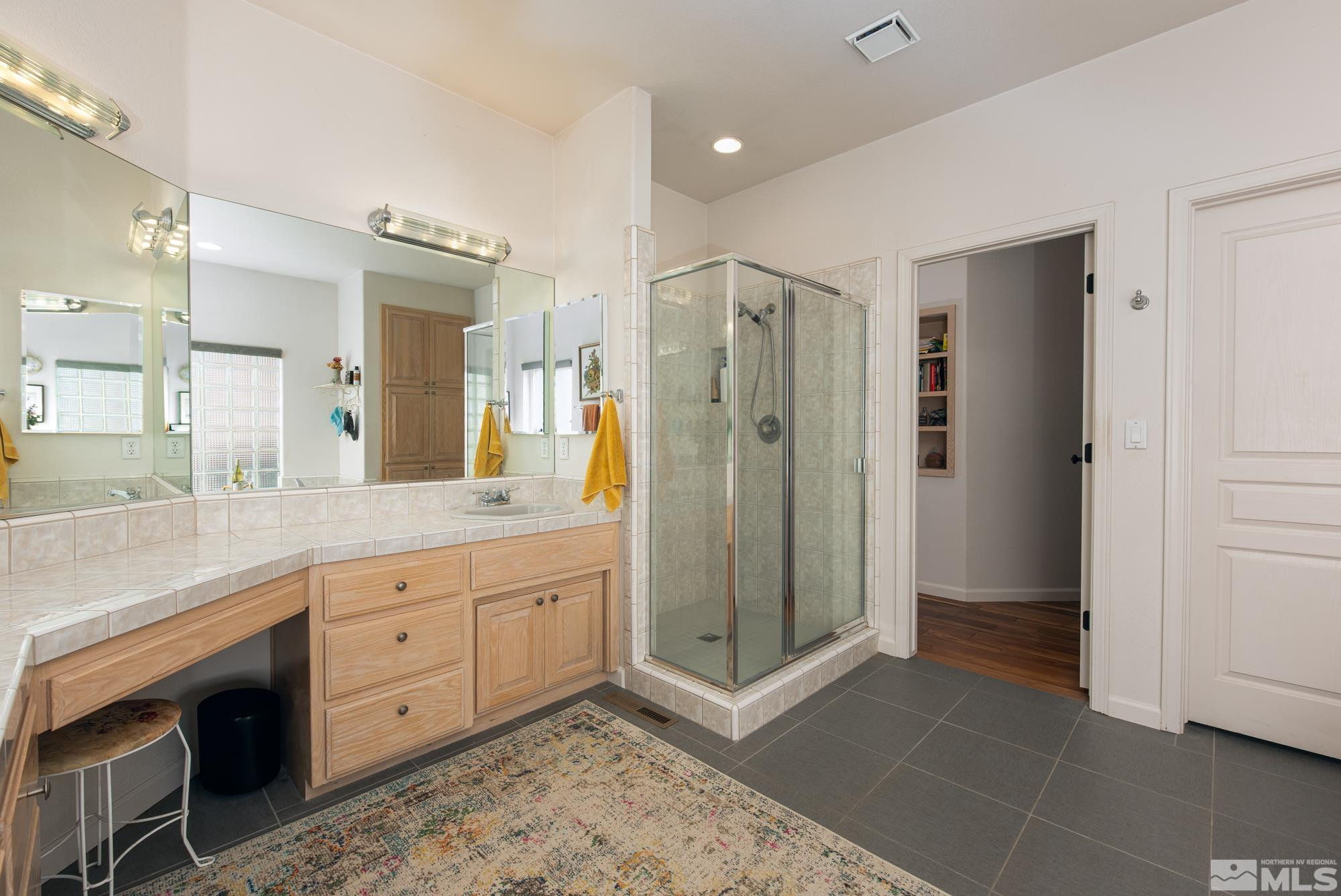 971 Fieldgate Way Gardnerville, NV 89460 - Photo 18 of 57 a bathroom with a shower sink and mirror