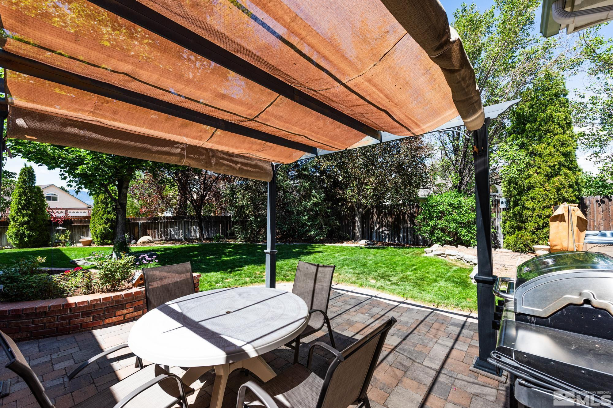 971 Fieldgate Way Gardnerville, NV 89460 - Photo 38 of 57 a view of a patio with table and chairs potted plants and a large tree