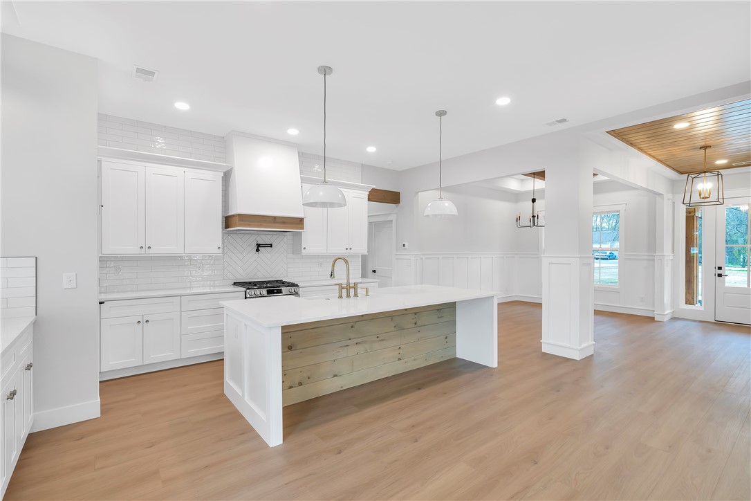 4554 Flat Rock Road Iva, SC 29655 - Photo 10 of 32 A well-lit, open-concept kitchen features a spacious island and gleaming wood flooring.