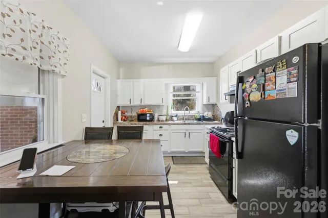 a kitchen with stainless steel appliances granite countertop a sink stove refrigerator and cabinets
