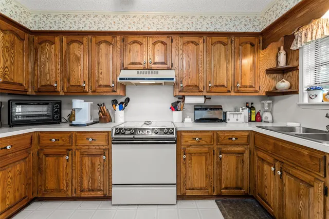 a kitchen with granite countertop wooden cabinets and a sink
