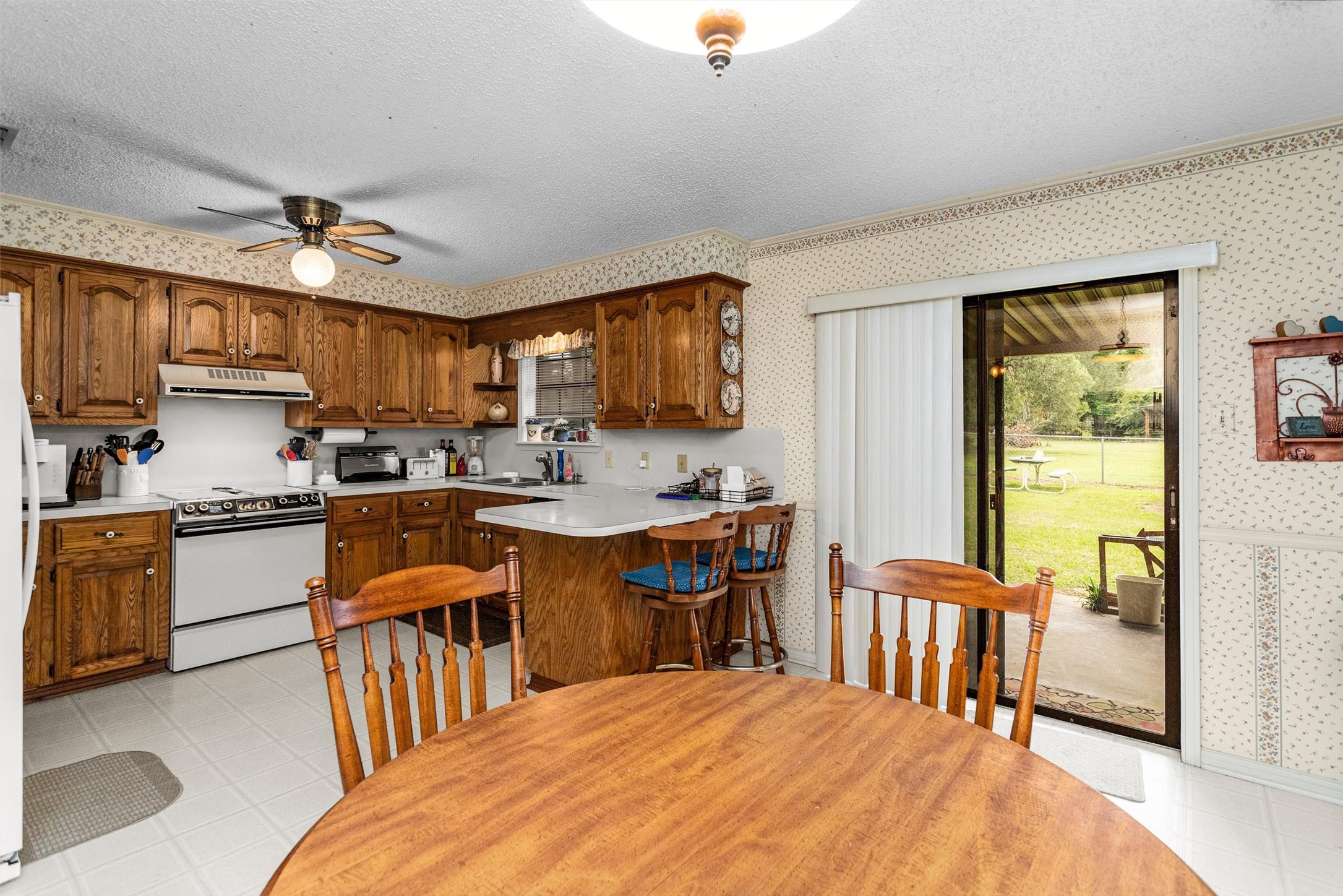 3219 Fm 1817 Elkhart, TX 75839 - Photo 13 of 31 a kitchen with stainless steel appliances granite countertop a stove a refrigerator a kitchen island a sink dishwasher a dining table and chairs with wooden floor