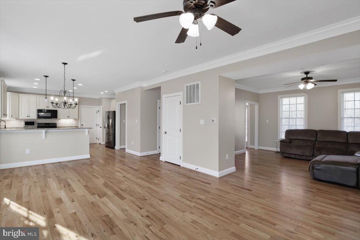 441 Shady Creek Road Clear Brook, VA 22624 - Photo 21 of 46 a view of a living room a kitchen island wooden floor and a ceiling fan